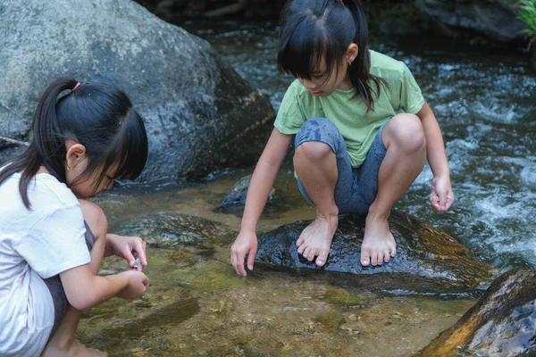 幸せな子供たちは川で遊んでいる 夏の川では2人の姉妹が海岸の砂で遊ぶのを楽しんでいます 屋外の楽しみ レクリエーション 子供たちとの学習活動 — ストック写真