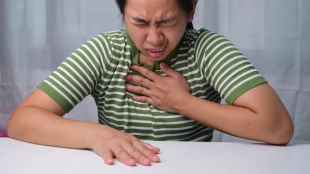 胸を痛みの表情で抱える女 女性は心臓病 心臓発作 心臓漏れや冠動脈疾患によって引き起こされる胸の痛みを持っています — ストック動画