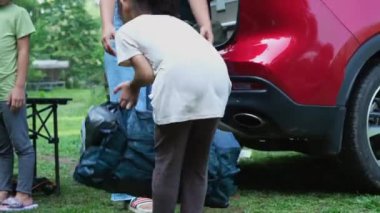 Aile kampı, çadırı korumak için annesine yardım eden çocuk. Anne ve kızı birlikte maceralı bir tatile çıkıyorlar. Sağlıklı yaşam tarzı ve eko-turizm.