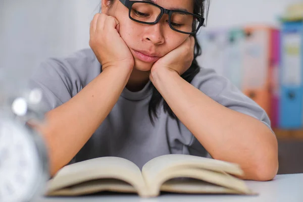 Tired Asian Woman Sitting Desk Reading Book Living Room — Stock Photo, Image
