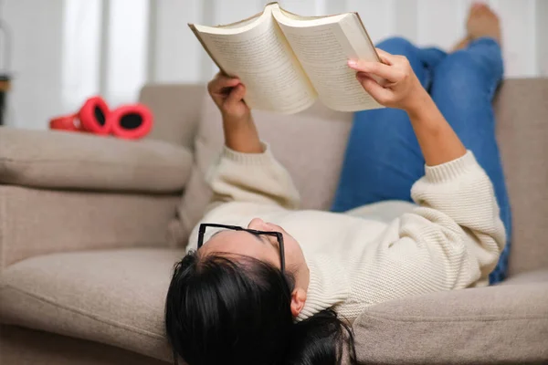 Happy Asian Woman Lying Sofa Reading Book Indoors Lifestyle Free — Stock Photo, Image