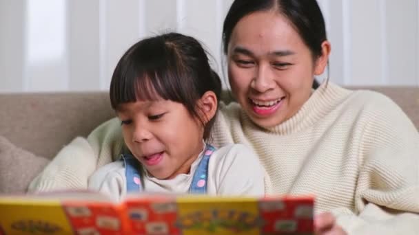 Madre Leyendo Libro Con Hija Sofá Casa Madre Feliz Leyendo — Vídeos de Stock