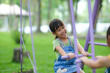 İki tatlı kız kardeş yaz boyunca oyun alanında oynarken eğleniyorlar. Sevimli küçük bir kız, gülücükler saçarak bir parkta at sallıyor. Çocuklar için aktif yaz tatili.