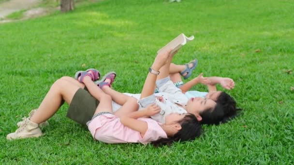 어머니와 공원에서 재미있게 즐기고 어머니와 정원에서 쉬면서 딸에게 동화를 줍니다 — 비디오