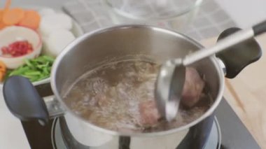 Aşçılık - Şefin elleri domuz pirzolasını mutfaktaki kaynar suyun içine koyuyor. Sebzeli (et suyu) domuz eti hazırlıyorum. Ev yapımı bulyon tarifi..