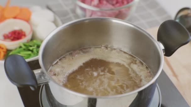 厨师的手在厨房里把猪排放进一壶开水里 用蔬菜 在锅里配制猪肉 自制肉汤菜谱 — 图库视频影像