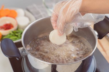 Ev yapımı bulyon tarifi. Şefin elleri et suyu (et suyu) ve sebze hazırlıyor. Mutfakta yemek yap..