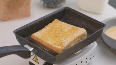 Yumurtadaki ekmek kırıntıları tavada kızartılır. Yakın plan. Kahvaltıda kızarmış ekmek ve süt..