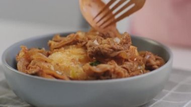 Kore yemeği - Kaşık tutan eller kızarmış kimchi ve klozette pilav ile Kurobuta domuz eti yiyor. Öğle yemeği için Kore ev yemeği.