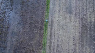 Gün batımında tarlalarda çalışan Asyalı çiftçi kimyasallar veya gübreler püskürtüyor.
