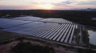 Günbatımı gökyüzü arka planında güneş panelleri, yeşil temiz Alternatif enerji kavramı. Gün batımı ışınları fotovoltaik enerji santralinin üzerinde.