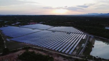 Günbatımı gökyüzü arka planında güneş panelleri, yeşil temiz Alternatif enerji kavramı. Gün batımı ışınları fotovoltaik enerji santralinin üzerinde.