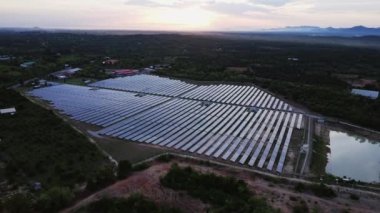 Günbatımı gökyüzü arka planında güneş panelleri, yeşil temiz Alternatif enerji kavramı. Gün batımı ışınları fotovoltaik enerji santralinin üzerinde.