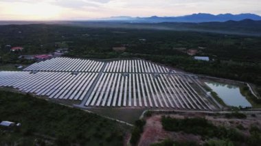 Günbatımı gökyüzü arka planında güneş panelleri, yeşil temiz Alternatif enerji kavramı. Gün batımı ışınları fotovoltaik enerji santralinin üzerinde.