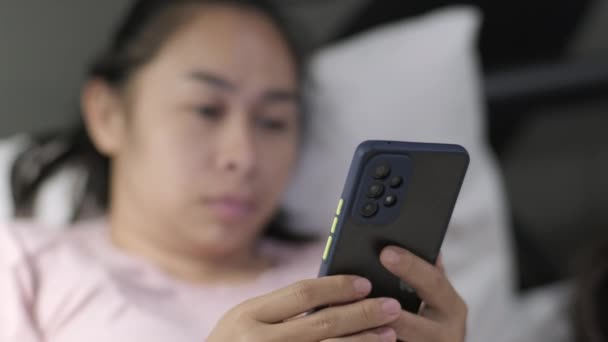 Fiatal Ázsiai Fekszik Fehér Ágyon Okostelefonon Játszik Éjszaka Egy Ágyban — Stock videók