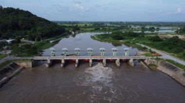 Beton barajın drenaj kanalından fışkıran suyun hava görüntüsü yağmur mevsiminde taşan suyun bir yoludur. Turbiş kahverengi orman sularının en üst görüntüsü Tayland 'daki bir barajdan akıyor..