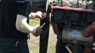 Uçuş teknisyenleri bir hava gösterisinde tek motorlu küçük bir uçağın uçuş öncesi denetimini veya bakımını yapıyor. Mühendisler küçük uçakları tamir ediyor..