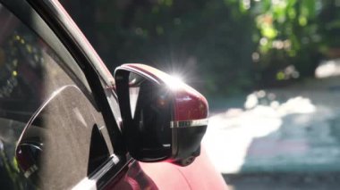 Arabanın yan aynasından güneş parlıyor. Park halindeki bir arabanın yan aynasına yansıyan güneş ışığı..