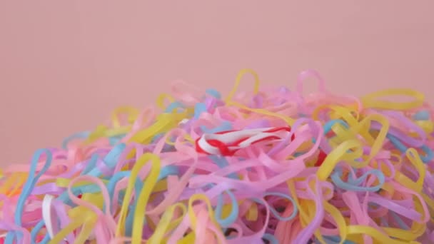 Bunte Gummibänder Isoliert Auf Rosa Hintergrund Bunte Kinderhaarbänder Flexibel Aus — Stockvideo