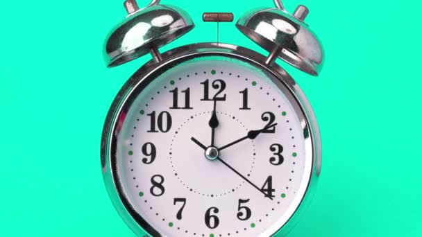 緑の背景に隔離された古典的なヴィンテージの目覚まし時計 速く動くレトロ警報時計 時計の手は速く動き 時刻の始まりは12時から1時まで — ストック動画