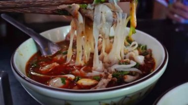 Lao usulü erişte, taze sebzelerle birlikte Vientiane, Laos 'taki yerel bir restoranın ahşap masasında servis edilir..