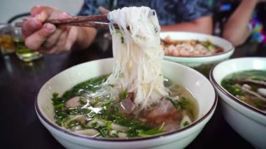 Lao usulü erişte, taze sebzelerle birlikte Vientiane, Laos 'taki yerel bir restoranın ahşap masasında servis edilir..