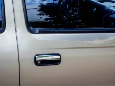 Eski arabanın gövdesinde pas ve boya hasarı var. Eski boyaları araba gövdesine döküyorum.