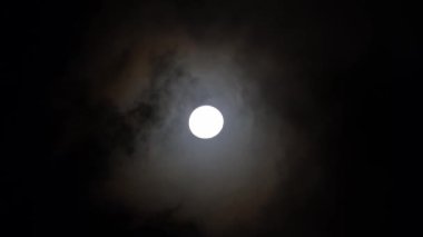 Dolunay bulutlu gece gökyüzünde parlıyor. Doğada güzellik