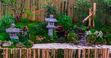Minimum Japon bahçesi küçük taş fener, bambu çeşmesi, yosun ve çiçeklerle dolu..