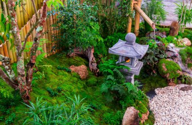 Minimum Japon bahçesi küçük taş fener, bambu çeşmesi, yosun ve çiçeklerle dolu..