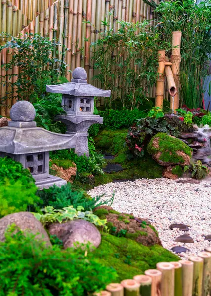 stock image Minimal Japanese garden in home with small stone lantern and bamboo fountain and moss and flowers.