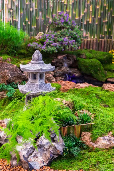 stock image Minimal Japanese garden in home with small stone lantern and bamboo fountain and moss and flowers.