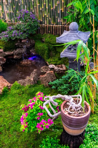 stock image Minimal Japanese garden in home with small stone lantern and bamboo fountain and moss and flowers.