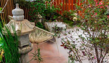 Minimum Japon bahçesi küçük taş fener, bambu çeşmesi, yosun ve çiçeklerle dolu..