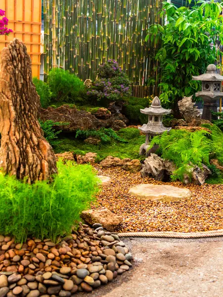 stock image Minimal Japanese garden in home with small stone lantern and bamboo fountain and moss and flowers.