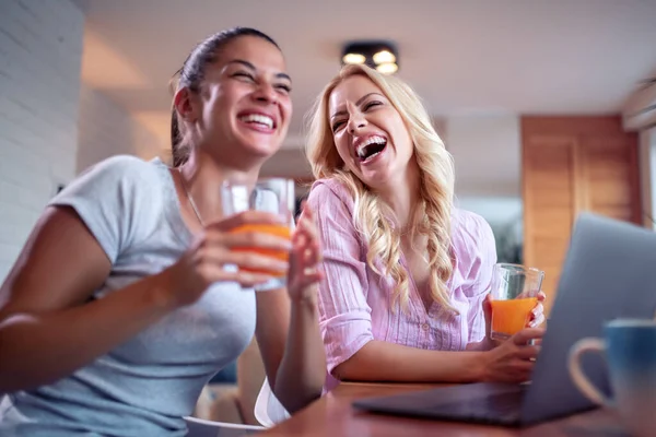 Dos Chicas Usando Laptop Casa Bebiendo Jugo Sonriendo Divirtiéndonos Juntos — Foto de Stock