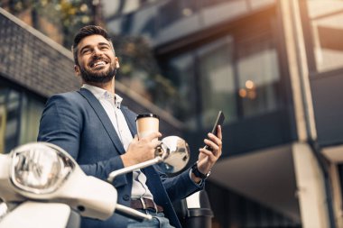 Dışarıdaki işadamının portresi, akıllı telefon kullanıyor. Ofisinin yakınında akıllı telefon kullanan güler yüzlü bir işadamı..