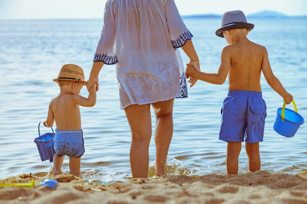 Happy family holidays.Family of three having fun on tropical beach.