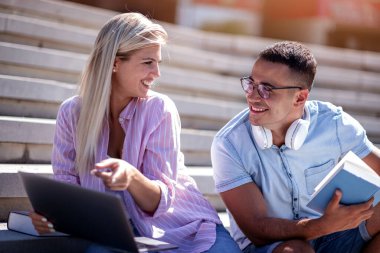 Young students using laptop in the city. Online education.