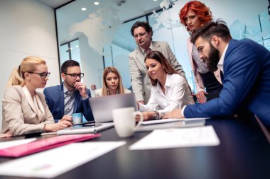 İş adamları konferans sırasında dizüstü bilgisayar kullanıyor, konuşuyor ve gülümsüyor..