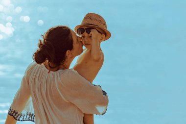Mother with little boy playing on the beach, enjoying on summer vacation.