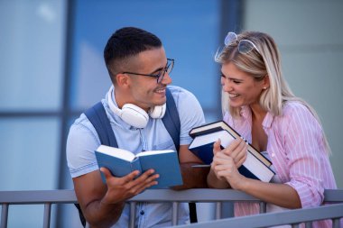 Portrait of young people outdoors with books, they learning together.