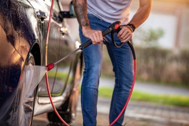 Araba yıkamada arabasını temizleyen genç adam.. 