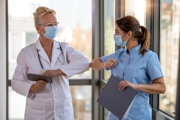 Smiling Doctors Wearing Protective Face Masks Greeting Bumping Elbows Workplace — Fotografia de Stock