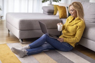 Woman using laptop at home,relaxing after work and drink coffee.