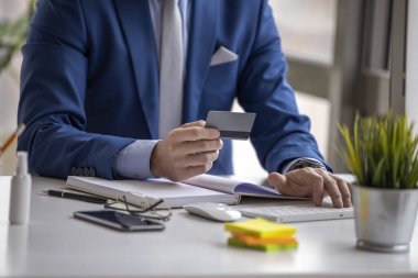 Modern ofiste bilgisayar üzerinde çalışan bir iş adamı. Proje yöneticisi ofisinde çalışma planlıyor, kapat..