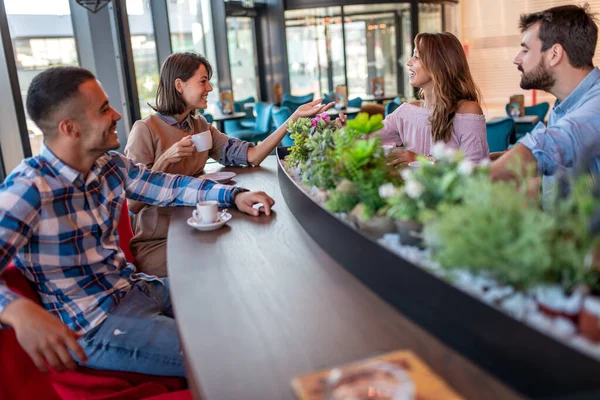 Genç arkadaşlar restoranda harika bir zamandı. Bir kafede otururken ve gülümseyen gençlerin grup.