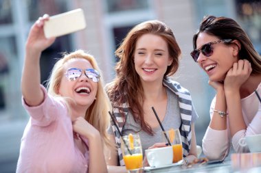 Kızlar selfie çeker. Arkadaşlık, eğlence, mutluluk ve insanlar konsepti.