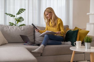 Evden çalışan, telefon kullanan bir kadın..