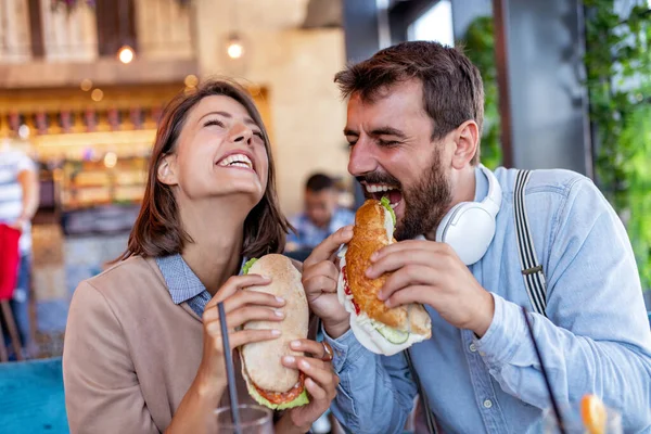 식당의 남녀는 샌드위치를 먹으면서 즐거운 시간을 보냅니다 즐거움 — 스톡 사진